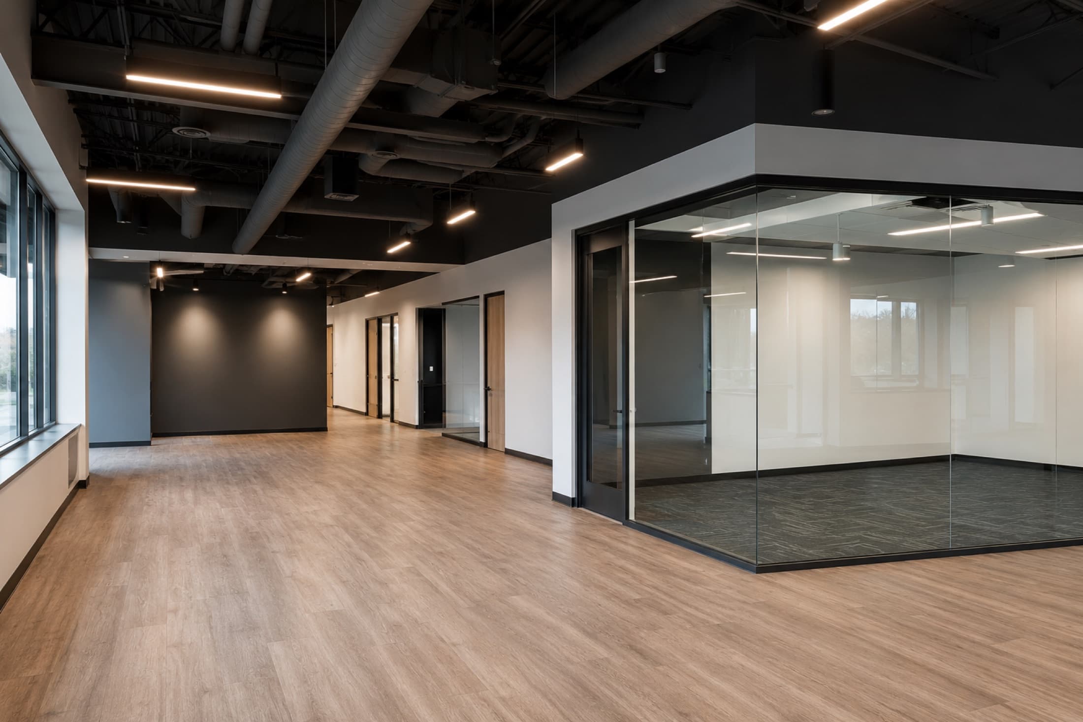 Commercial office interior with glass partition and exposed ceiling